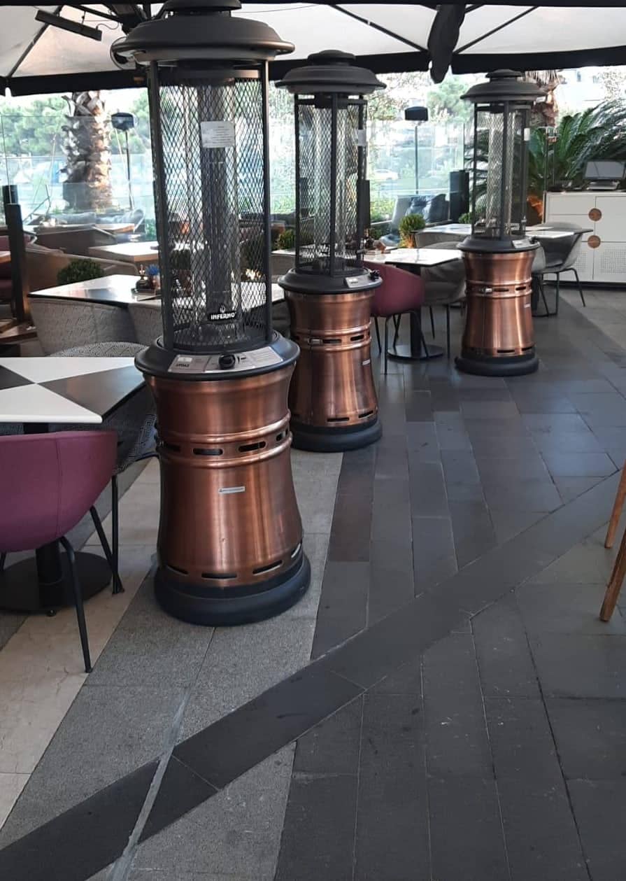 Restoran terasında yan yana bakır fener ısıtıcılar